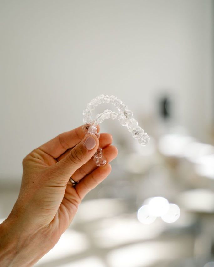 Una mano sostiene un alineador invisible